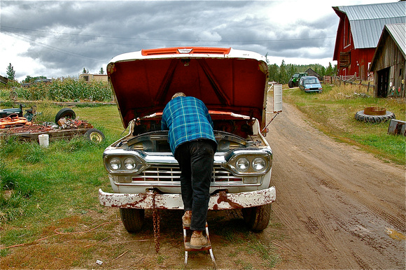 Ralph Banderob tinkers with a hay truck, Hells Gulch, Idaho